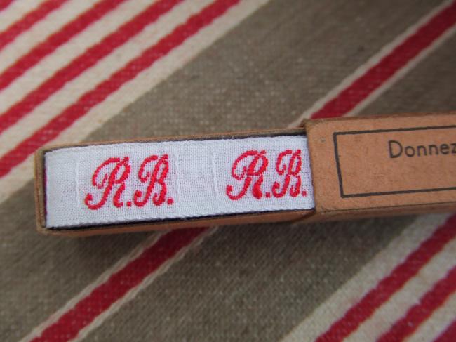 Boite de ruban blanc avec initiales 'RB' tissées en rouge 1920, Textinoms