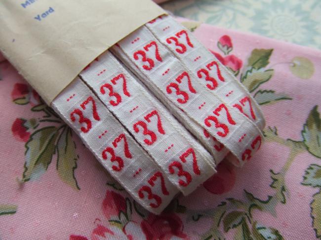 Ancien ruban de couleur blanche tissé numéro rouge, grand chiffre n°37