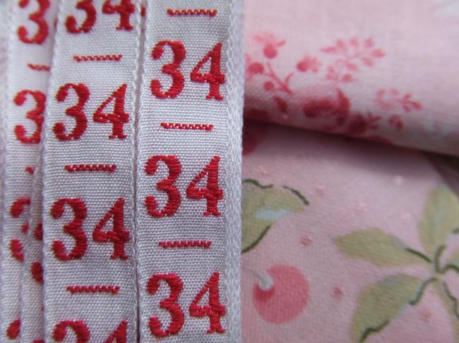 Ancien ruban de couleur blanche tissé numéro rouge, grand chiffre n°34
