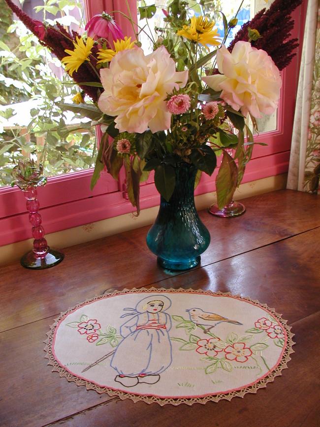 Charmant centre de table brodé d'un petit enfant et son oiseau