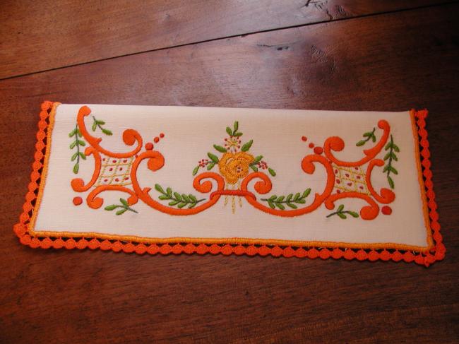 Charmant range-serviette brodé de volutes et petites fleurs oranges