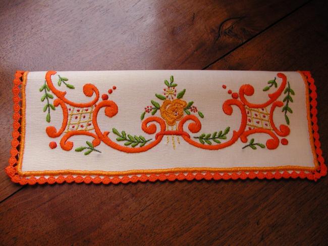 Charmant range-serviette brodé de volutes et petites fleurs oranges