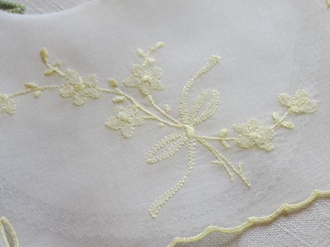 Adorable bavoir de bébé en voile brodé d'un bouquet de fleurs jaunes