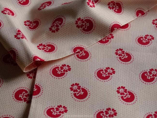 Coupon de coton à fond beige rosé avec motif de fleurs stylisées framboise