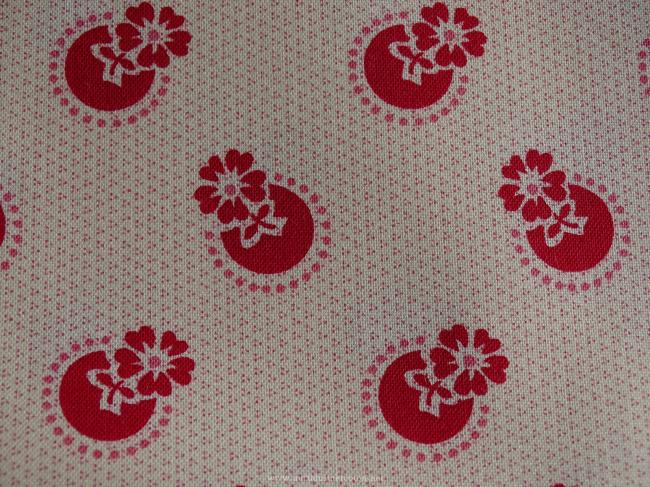 Coupon de coton à fond beige rosé avec motif de fleurs stylisées framboise