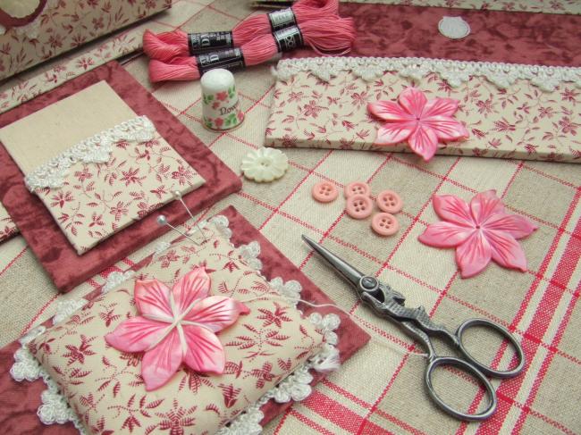 Merveilleux bobinoir en nacre rose ciselée en forme de clématite