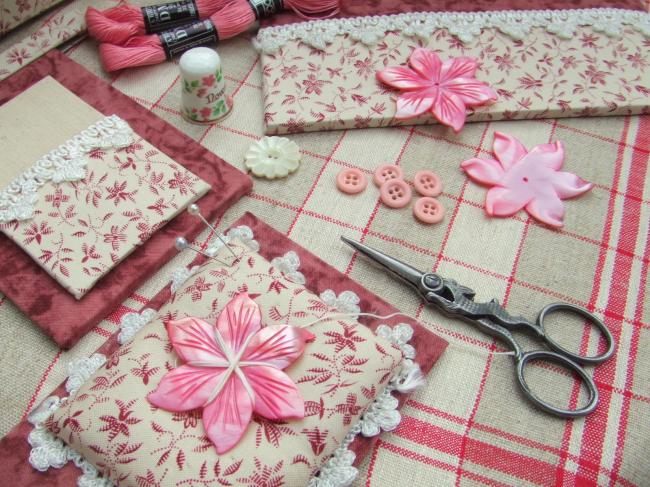 Merveilleux bobinoir en nacre rose ciselée en forme de clématite