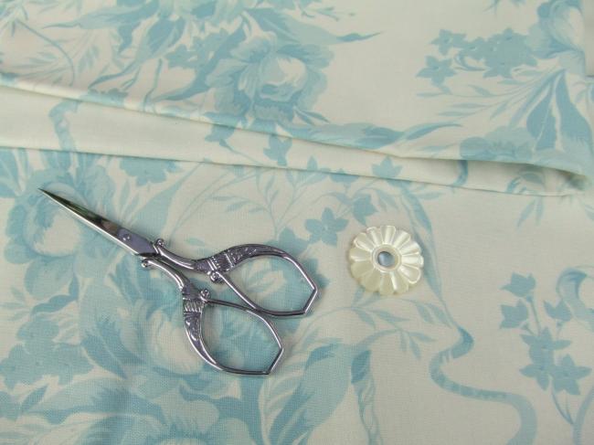Coupon de coton à fond écru à décor de bouquets de roses enrubannées, bleu pâle