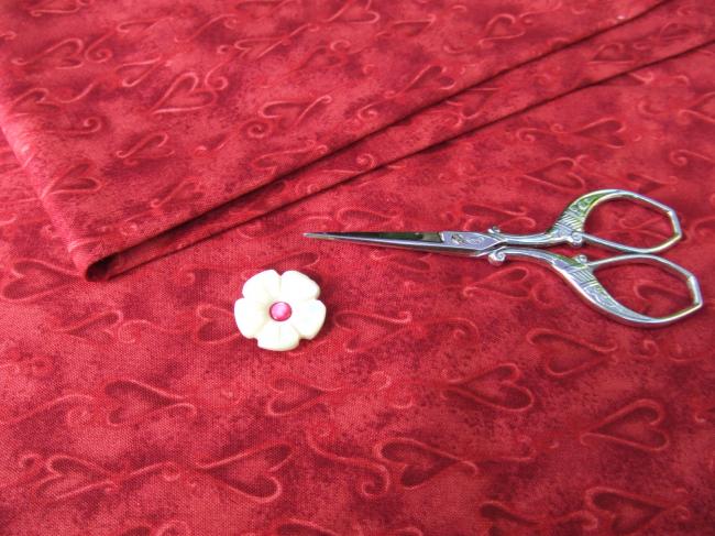 Coupon de coton à fond rouge grenat avec impression de coeurs stylisés